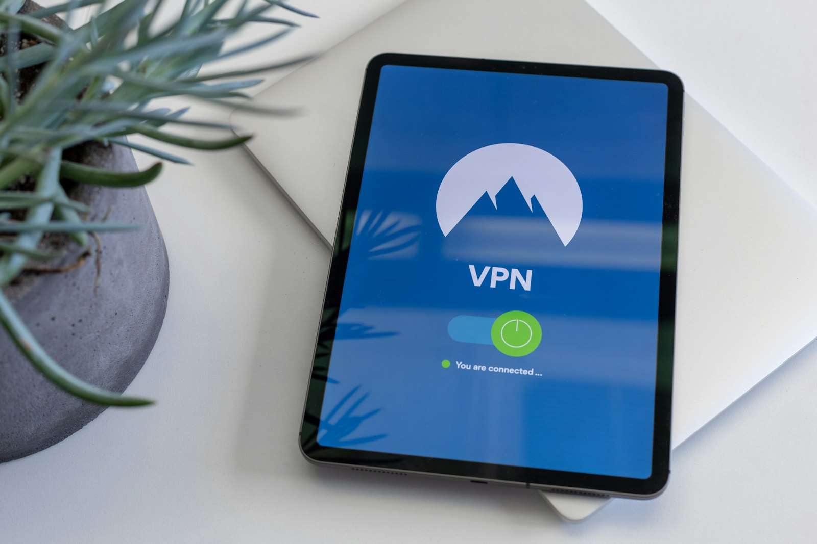 Tablet on a desk showing a VPN app connected, with the on/off toggle switched on